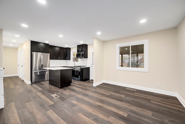 kitchen featuring dark wood-type flooring, a kitchen island, and stainless steel appliances