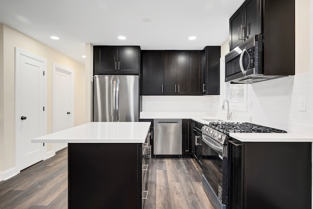 kitchen with a kitchen island, sink, dark hardwood / wood-style floors, and stainless steel appliances