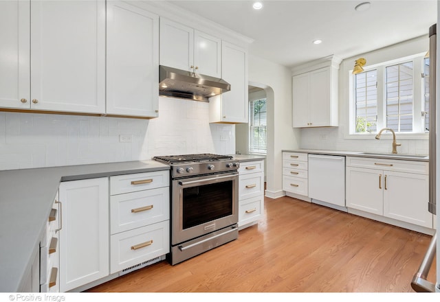 kitchen featuring white cabinetry, sink, white dishwasher, light hardwood / wood-style flooring, and high end stainless steel range