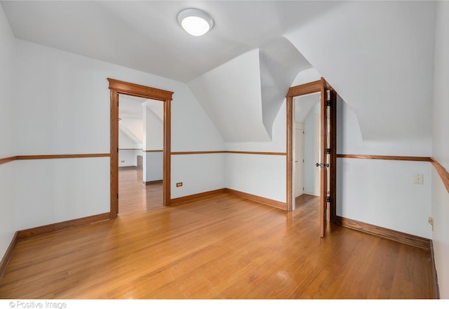 bonus room featuring light wood-type flooring and lofted ceiling