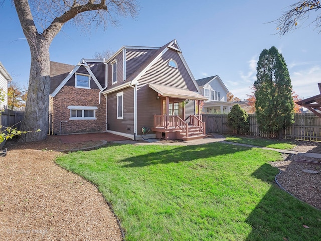 rear view of house featuring a lawn and a deck