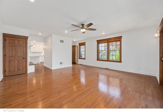 unfurnished room with light hardwood / wood-style floors, ceiling fan, and crown molding