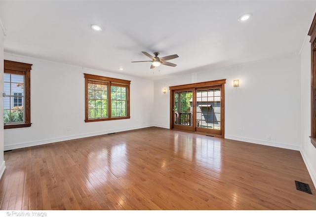 spare room with hardwood / wood-style flooring, ceiling fan, and plenty of natural light