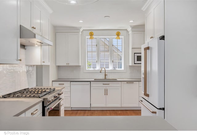 kitchen featuring white cabinets, high end appliances, decorative backsplash, and sink