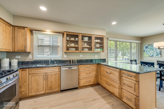 1019 N Webster St, Naperville, IL 60563 - kitchen featuring appliances with stainless steel finishes, a sink, a peninsula, dark stone countertops, and recessed lighting