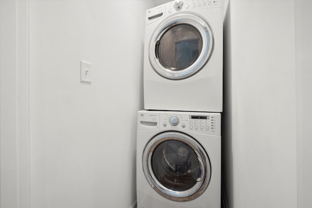 clothes washing area with stacked washer and dryer