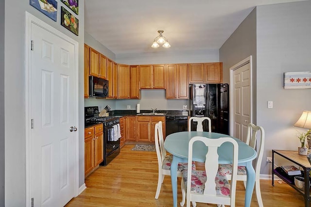 kitchen with light wood-type flooring, sink, and black appliances