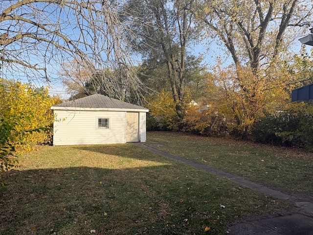 view of yard with a garage and an outbuilding