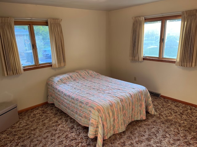 bedroom with carpet flooring and a baseboard radiator