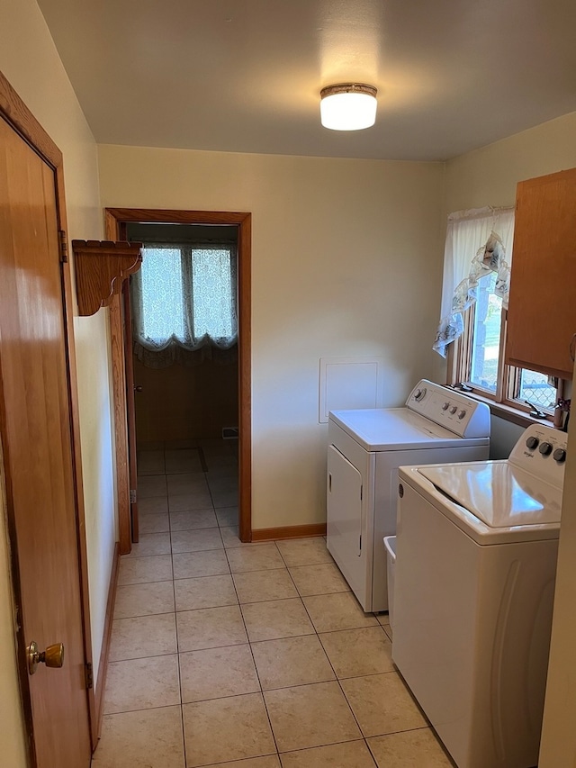 laundry room with washing machine and dryer, plenty of natural light, and light tile patterned flooring