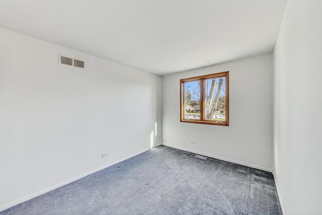 spare room featuring dark carpet