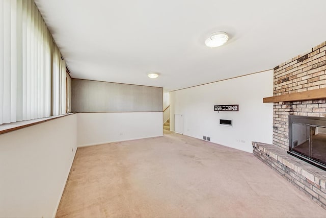 unfurnished living room with a fireplace and light carpet