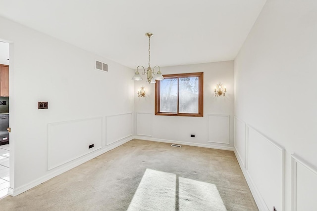 unfurnished dining area featuring light colored carpet and an inviting chandelier