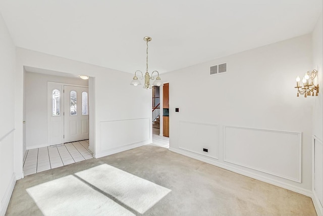 interior space featuring light carpet and a chandelier