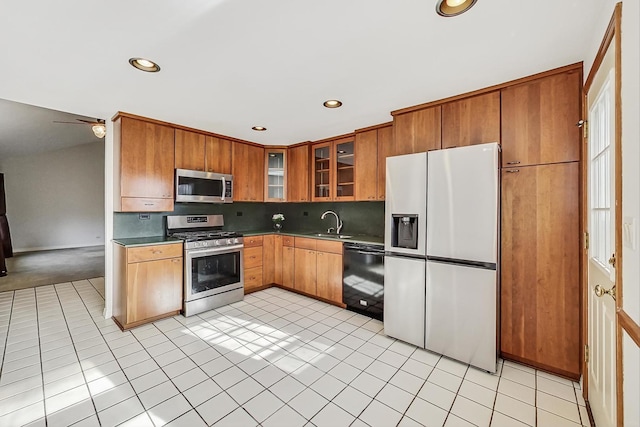 kitchen with stainless steel appliances, sink, light tile patterned floors, and backsplash