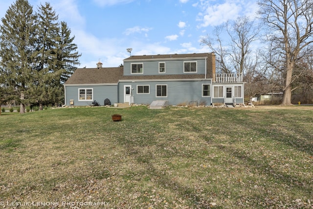 back of property featuring a balcony and a yard