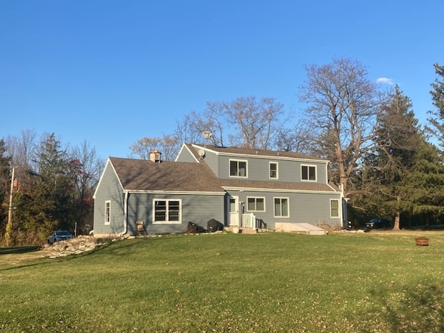 rear view of property featuring a yard