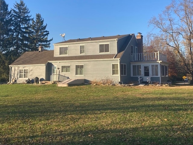 back of property featuring a lawn and a balcony