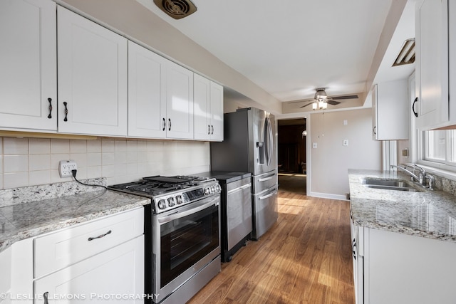 kitchen with hardwood / wood-style floors, white cabinetry, sink, and appliances with stainless steel finishes