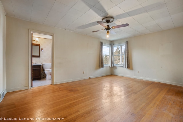 spare room featuring light wood-type flooring, ceiling fan, and sink