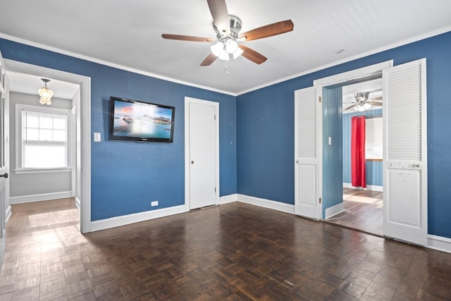 empty room with dark parquet flooring, ceiling fan, and ornamental molding