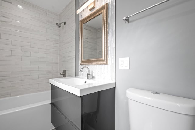 full bathroom with vanity, tiled shower / bath combo, and toilet