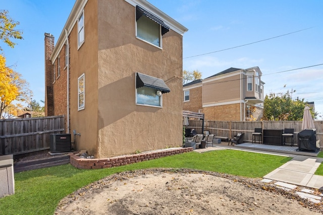 exterior space featuring a patio, central AC, and a lawn