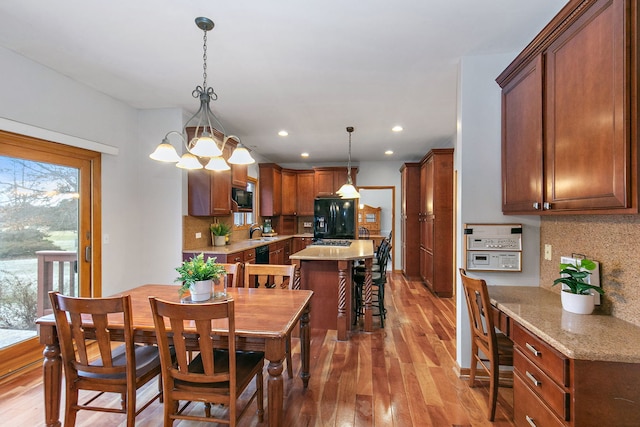 dining area featuring light wood-type flooring, an inviting chandelier, and sink