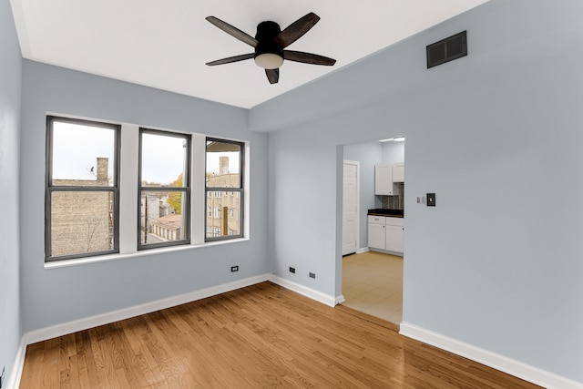 spare room featuring ceiling fan and light hardwood / wood-style floors