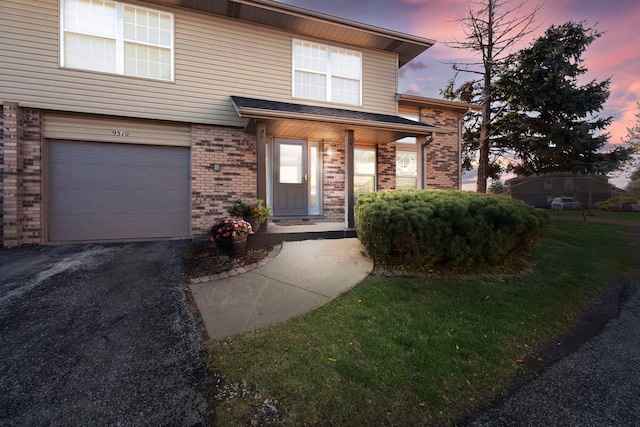 view of front of house featuring a garage and a yard