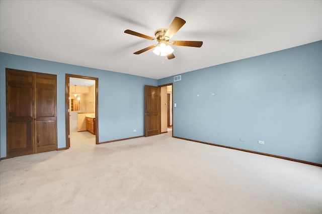 unfurnished bedroom featuring ensuite bathroom, ceiling fan, and light colored carpet