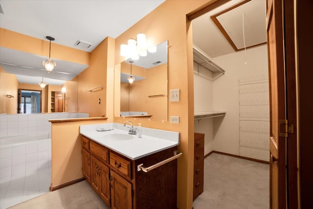 bathroom featuring vanity and tiled tub