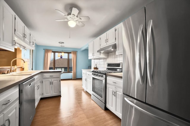 kitchen featuring white cabinetry, decorative light fixtures, and appliances with stainless steel finishes