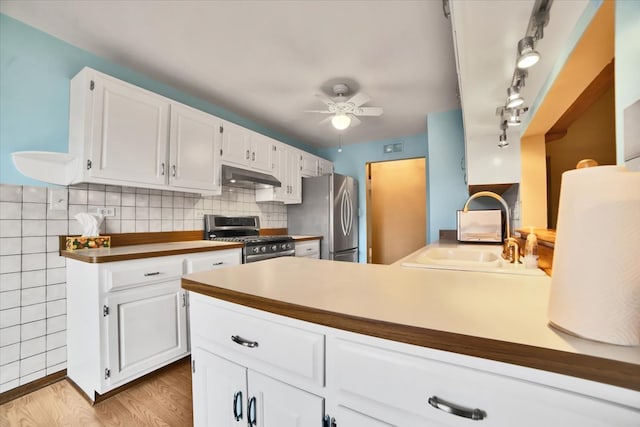 kitchen featuring sink, ceiling fan, appliances with stainless steel finishes, light hardwood / wood-style floors, and white cabinetry