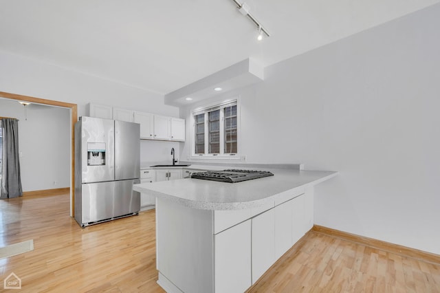 kitchen with stainless steel appliances, light hardwood / wood-style floors, white cabinets, and sink