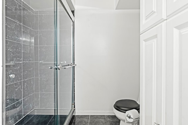 bathroom with toilet, tile patterned flooring, and a shower with door