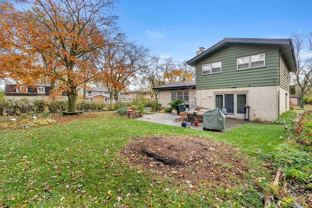 rear view of house featuring a lawn and a patio area