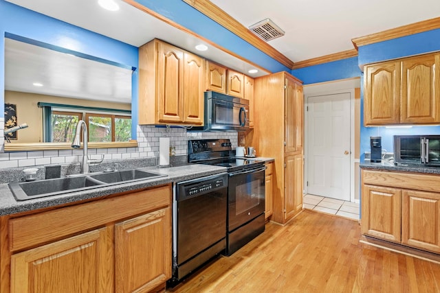 kitchen with sink, backsplash, crown molding, black appliances, and light wood-type flooring