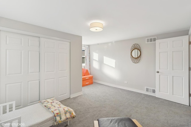 bedroom featuring a closet, visible vents, light carpet, and baseboards