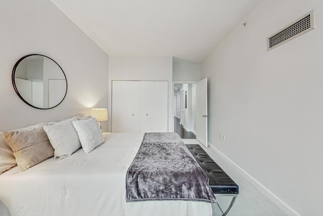 bedroom featuring carpet, lofted ceiling, and a closet