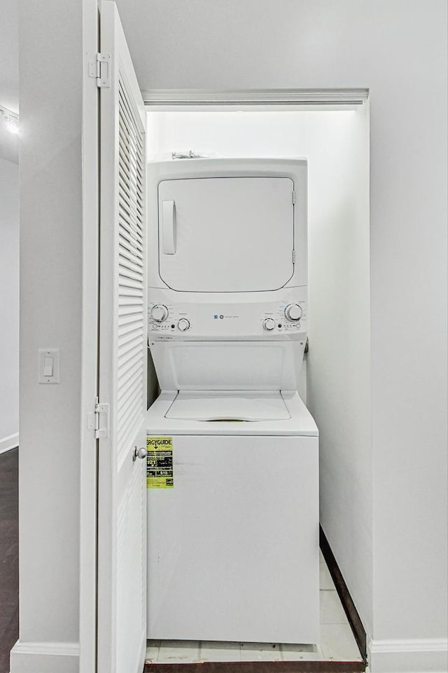 laundry room with light tile patterned floors and stacked washer and clothes dryer