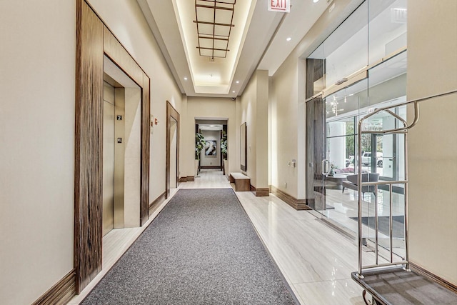 hall featuring a raised ceiling