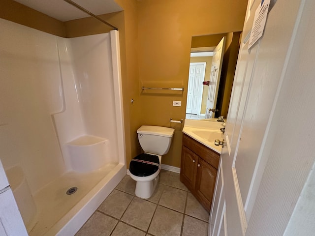 bathroom with walk in shower, toilet, vanity, and tile patterned floors