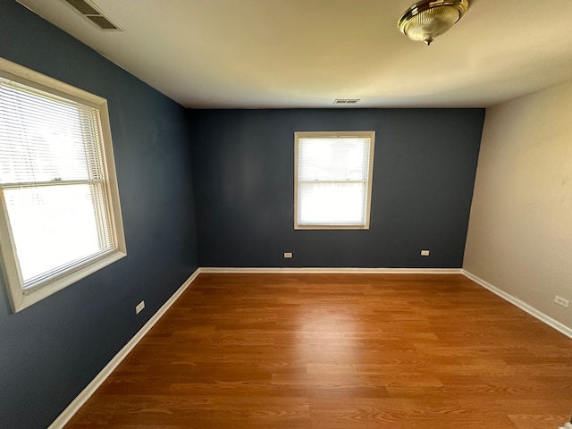 spare room with hardwood / wood-style flooring and plenty of natural light