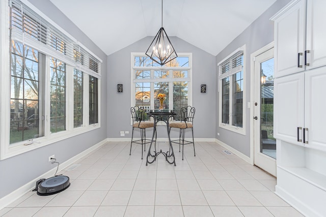 dining room featuring light tile patterned floors, vaulted ceiling, and an inviting chandelier