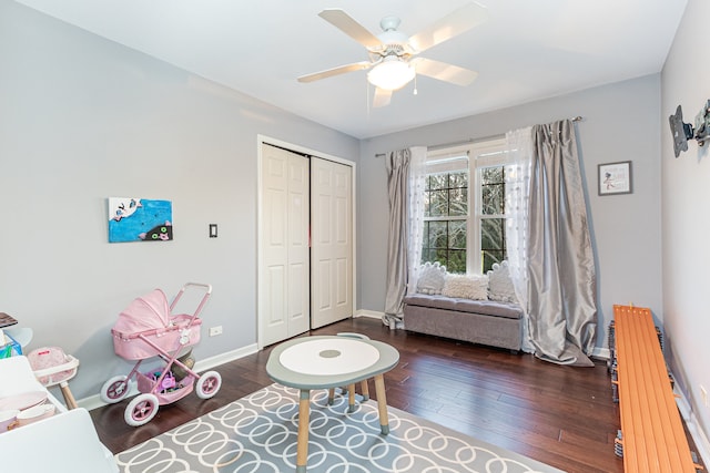 interior space with ceiling fan, dark hardwood / wood-style flooring, radiator heating unit, and a closet