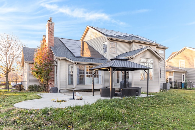 rear view of property featuring outdoor lounge area, solar panels, a lawn, central AC unit, and a patio