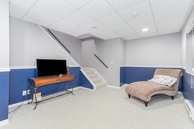 sitting room featuring carpet floors and a drop ceiling