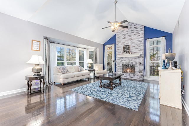 living room with dark hardwood / wood-style floors, a healthy amount of sunlight, high vaulted ceiling, and a brick fireplace