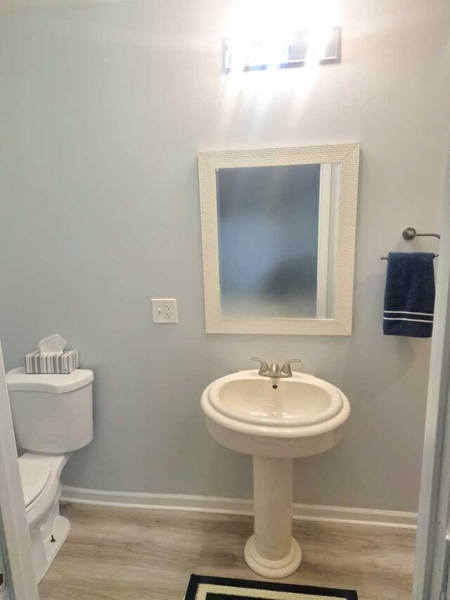 bathroom with hardwood / wood-style flooring and toilet